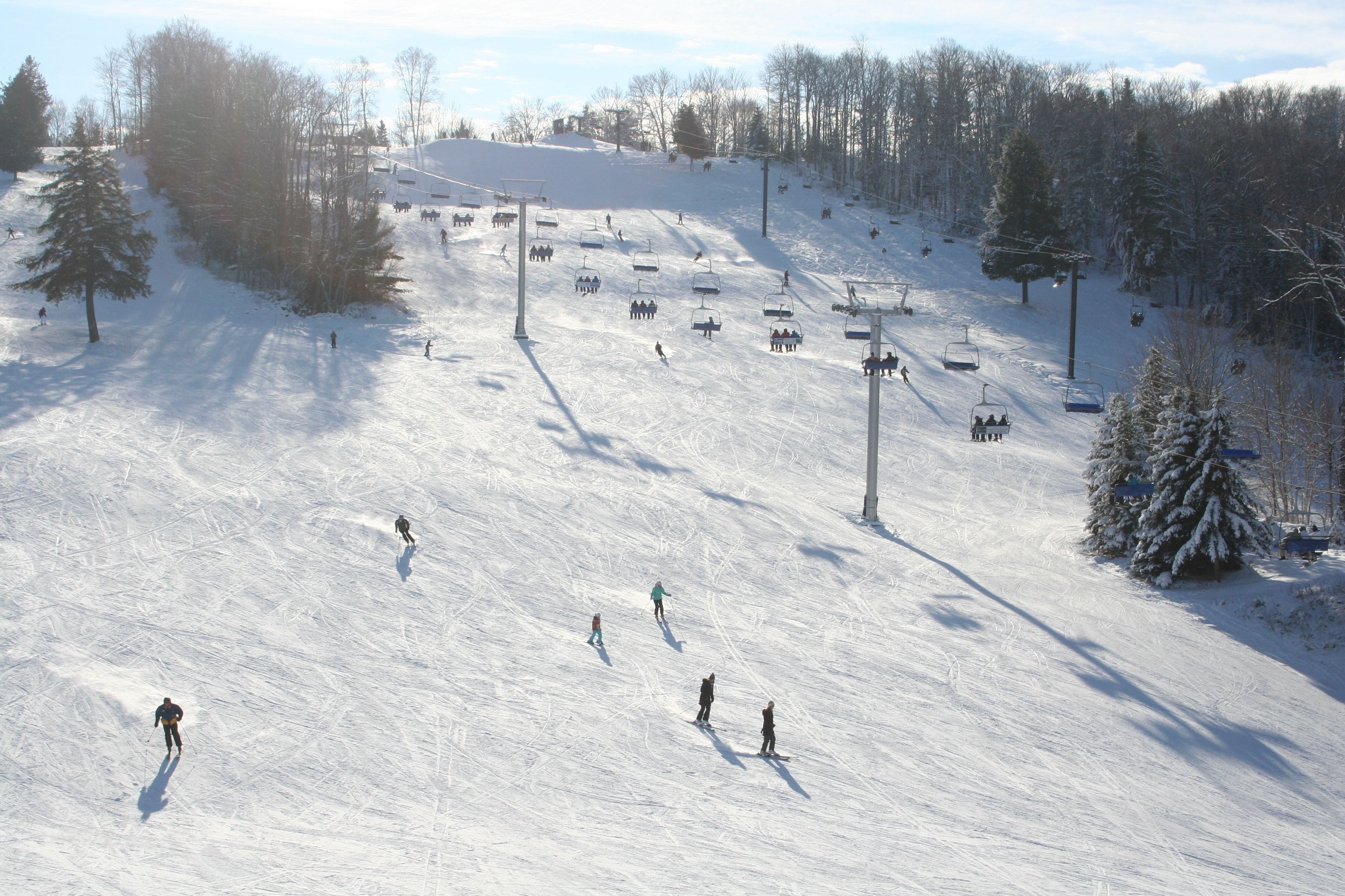A ski slope with skiers and a ski lift.