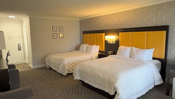 Ett hotellrum med två sängar, ett skrivbord och en mönstrad matta.