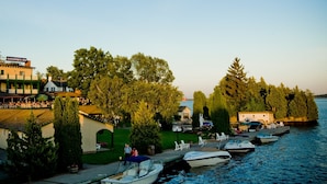 A marina with boats docked, a building labeled "GANANOQUE INN," and a grassy area with trees. - The Gananoque Inn (Gananoque)