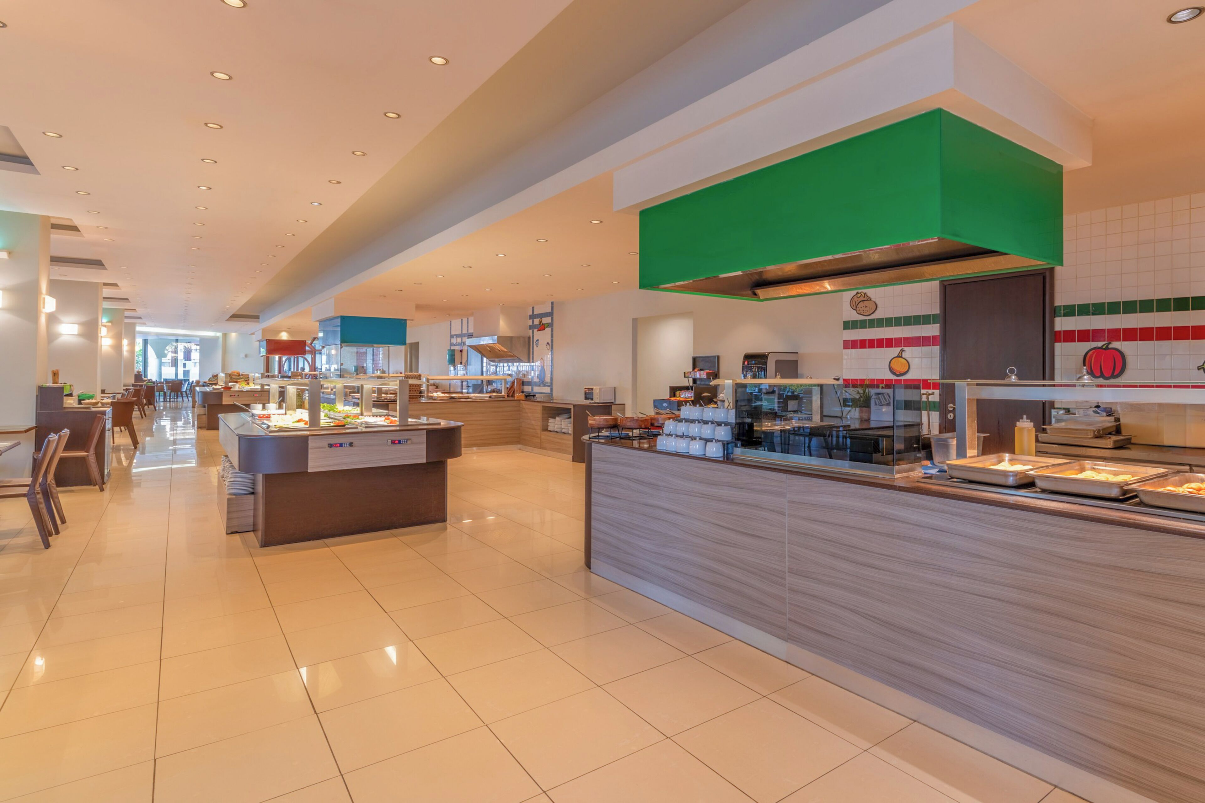 A modern hotel lobby with a buffet area, seating arrangements, and a view of the dining area.