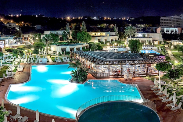 Una piscina al aire libre de temporada, sombrillas