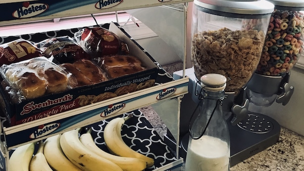 A kitchen counter with a variety of food items including a box of Hostess individually wrapped pastries, a container of cereal, and a bottle of milk. - Dutch Motel Palmyra (Palmyra)