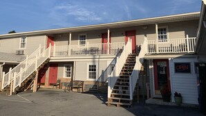 A two-story motel with a red door, a balcony, and a staircase. - Dutch Motel Palmyra (Palmyra)