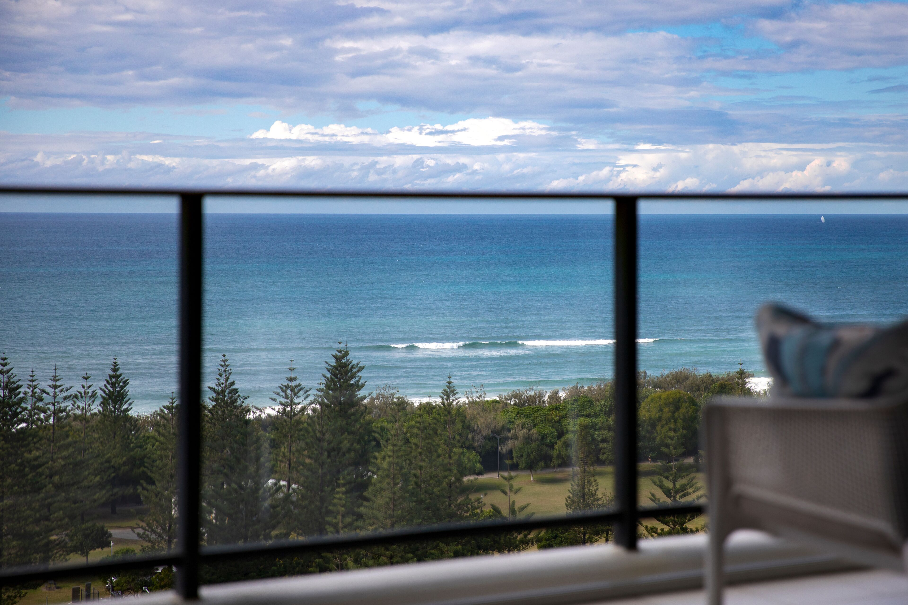 Ein Zimmer mit großem Fenster und Blick auf Strand und Meer.