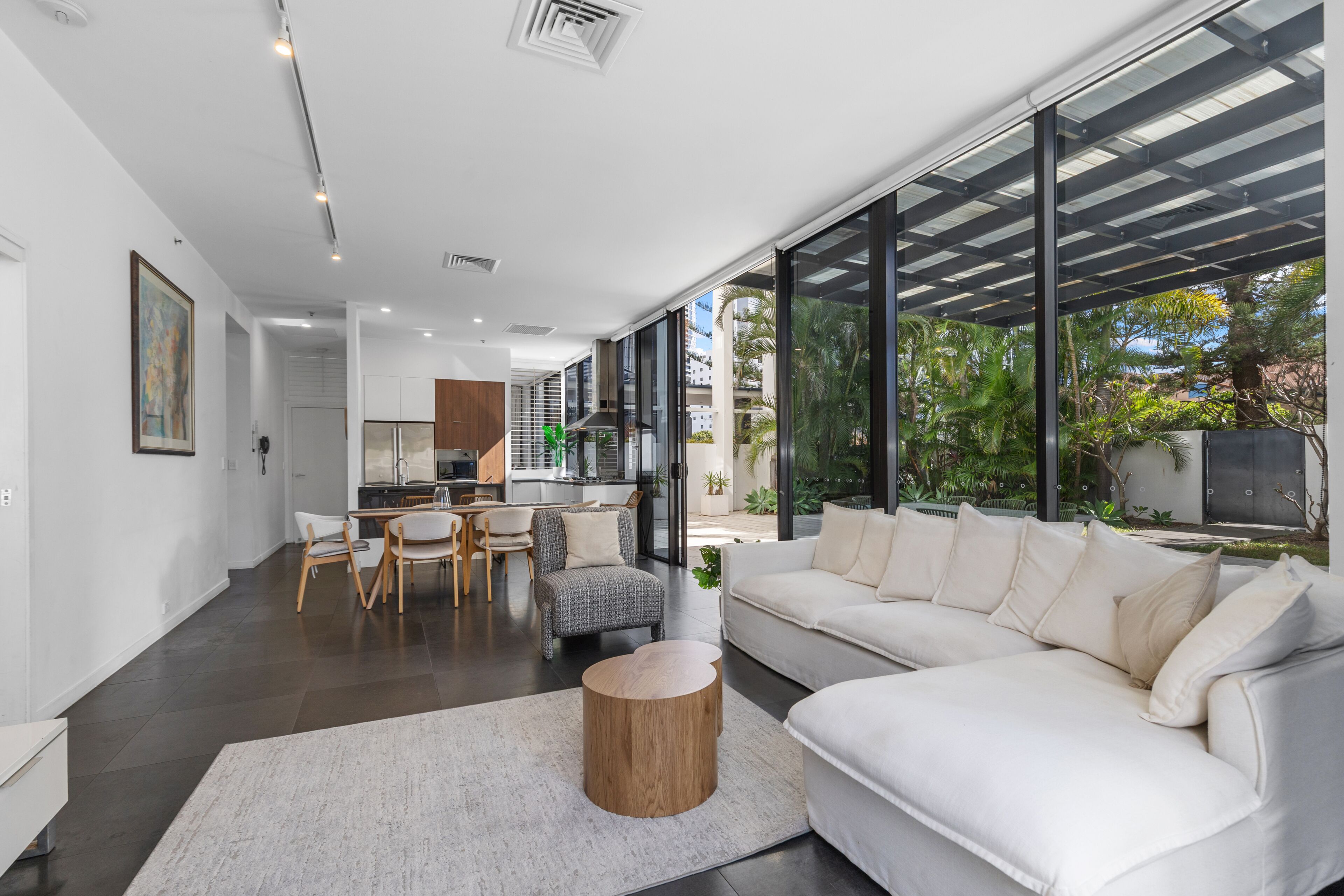 Un interior moderno con sofá blanco, comedor y cocina.