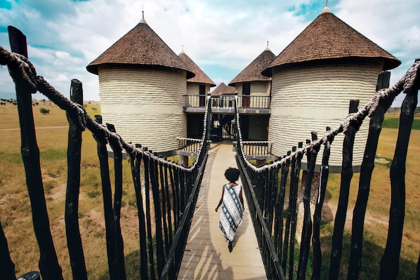 A pathway leading to a row of white buildings with brown roofs. - Salt Lick Safari Lodge (Taita Hills)
