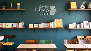 A library cafe with wooden shelves, books, and tables.
