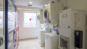 A laundry facility with washing machines, dryers, and a water dispenser.