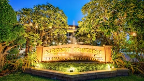 A well-lit hotel sign surrounded by lush greenery and a fountain in the background. - Khemara Angkor Hotel & Spa (Siem Reap)