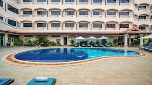 A hotel with a large indoor swimming pool surrounded by lounge chairs and umbrellas. - Khemara Angkor Hotel & Spa (Siem Reap)