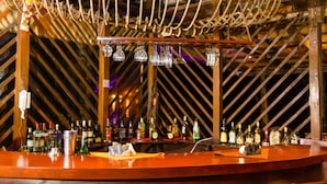 A bar area with a wooden ceiling and a curved counter.