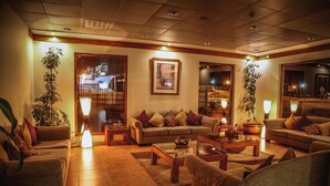 A cozy living room with a sofa set, two coffee tables, and a large potted plant. - Diego De Almagro Punta Arenas (Punta Arenas)