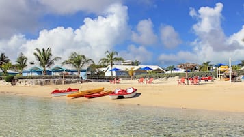 Enjoy water activities and relaxation on our serene beach with kayaks, paddleboards, beach chairs, and umbrellas.