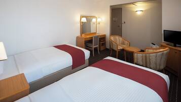 Una habitación de hotel con dos camas, un escritorio, una silla, un televisor y un espejo.