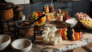 A buffet with various food items including fruits, cheeses, and condiments. - Hotel Morris Sydney - Handwritten Collection (Haymarket)