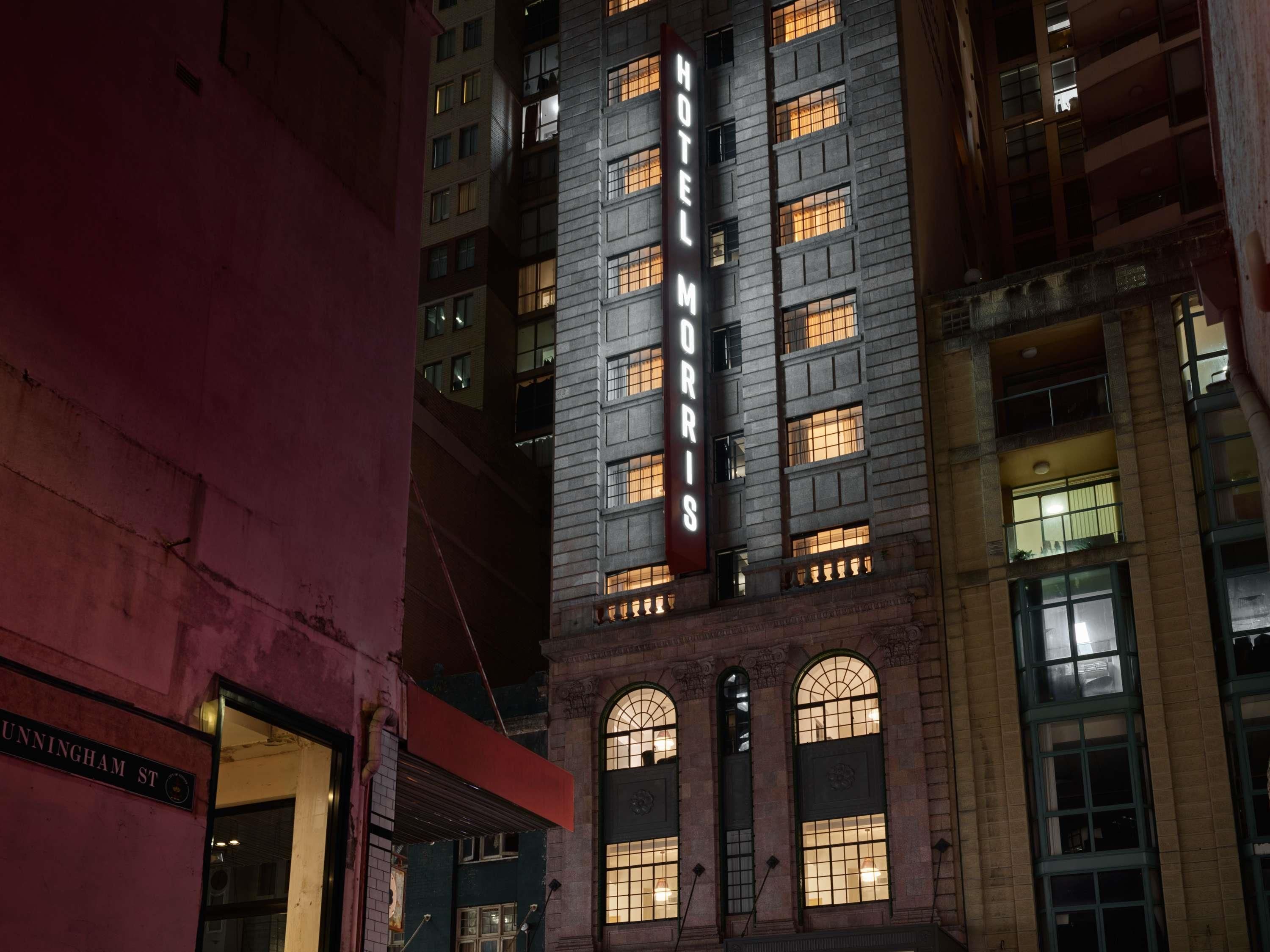 A multi-story building with a prominent 'HOTEL MORRIS' sign, large arched windows, and a classic architectural style.