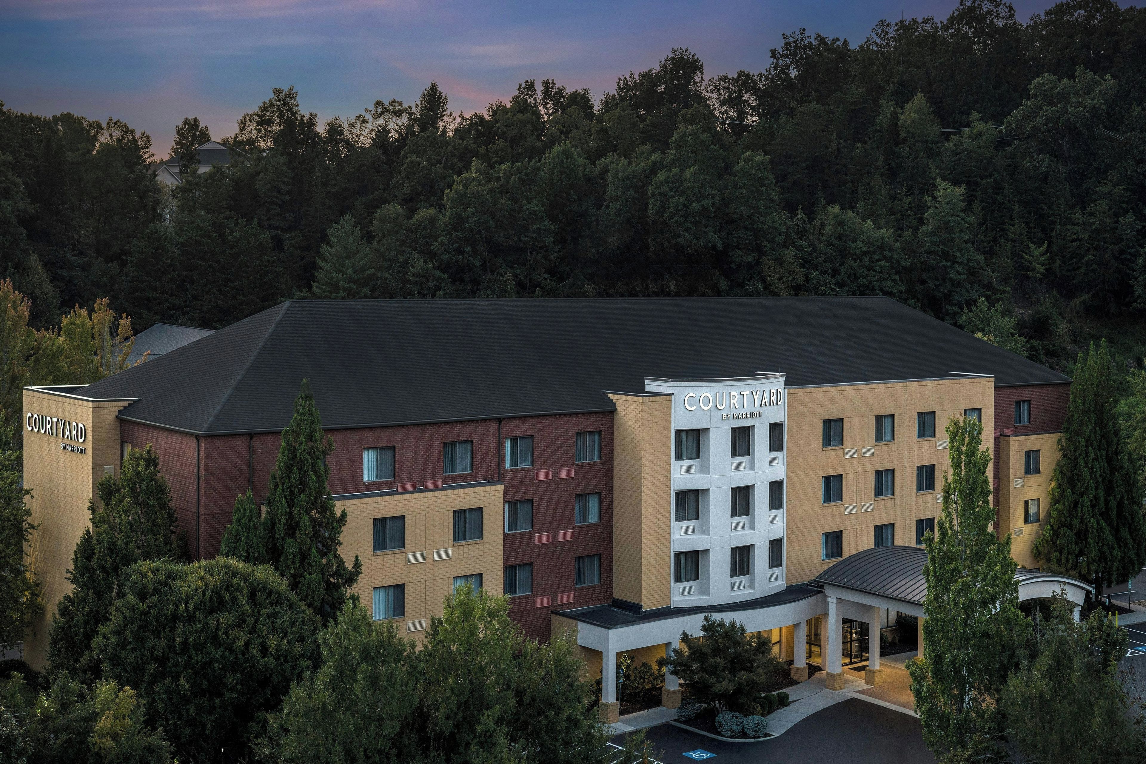 A Courtyard by Marriott hotel with a brick facade, multiple windows, and a covered entrance.