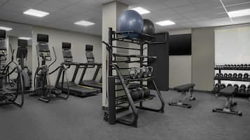 Une salle de sport équipée de tapis de course, de ballons d’exercice et d’appareils de musculation.