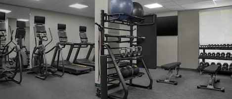 A gym with treadmills, exercise balls, and weight machines.