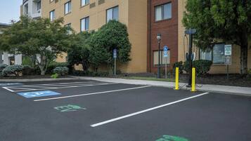 Un estacionamiento con espacios reservados para discapacitados y puntos de carga para vehículos eléctricos.