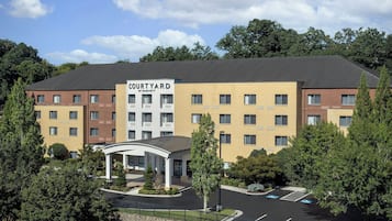 A Courtyard by Marriott hotel with a central courtyard, multiple floors, and a parking lot with handicapped parking spaces.