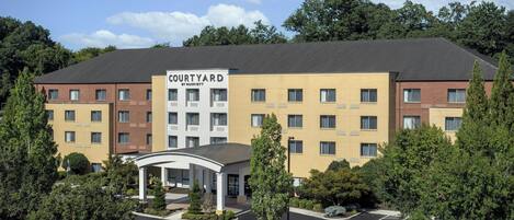 A Courtyard by Marriott hotel with a central courtyard, multiple floors, and a parking lot with handicapped parking spaces.