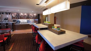 A modern hotel lobby with a bar area, seating, and a reception desk. - Courtyard by Marriott Blacksburg (Blacksburg)