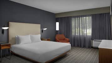 Habitación de hotel con una cama grande, una silla, un escritorio y una ventana con cortinas.