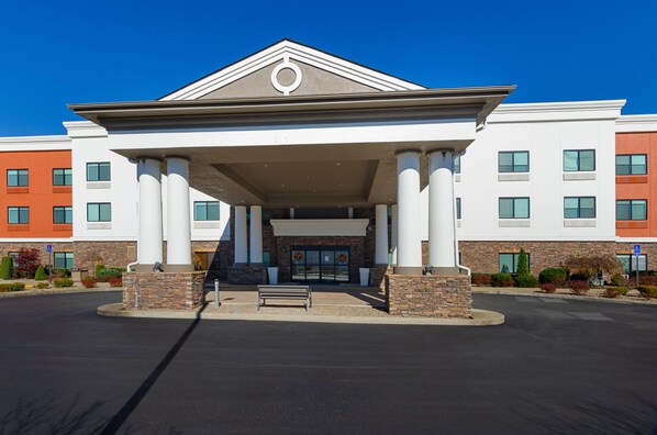 A building with a covered entrance, columns, and a bench in front. - Holiday Inn Express Hotel & Suites Weston by IHG (Weston)