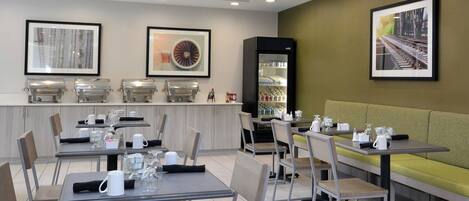 A modern dining area with tables, chairs, and a seating area.