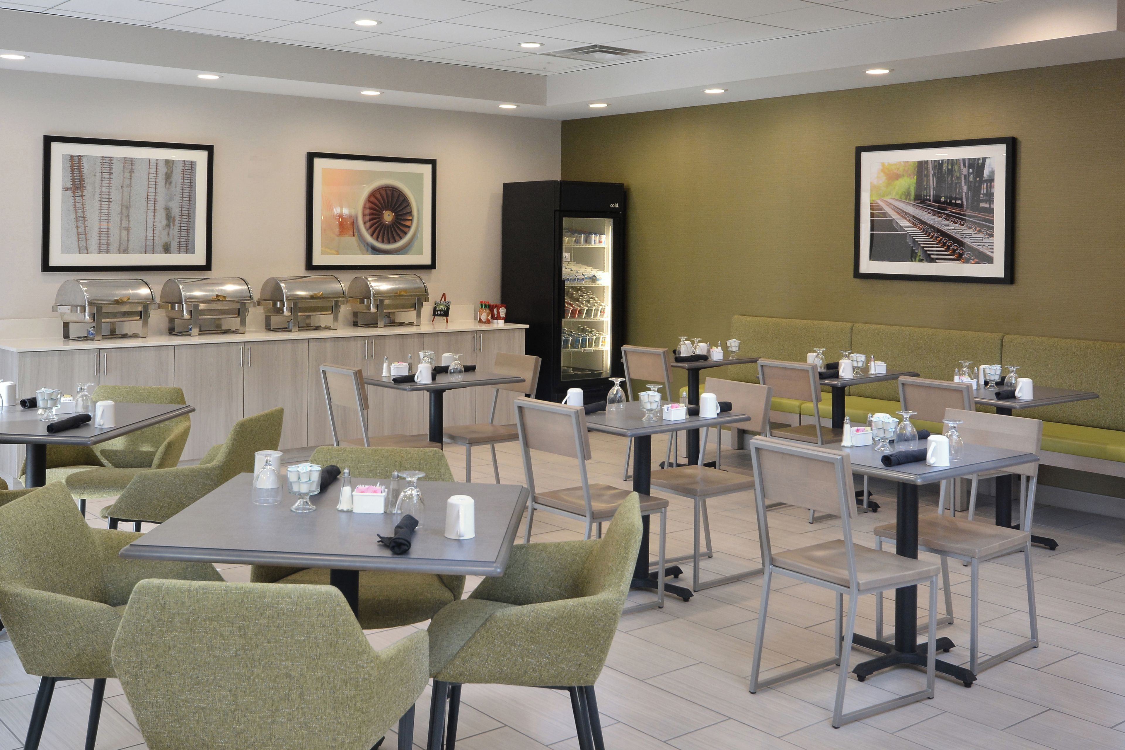 A hotel dining area with tables, chairs, and a buffet station.