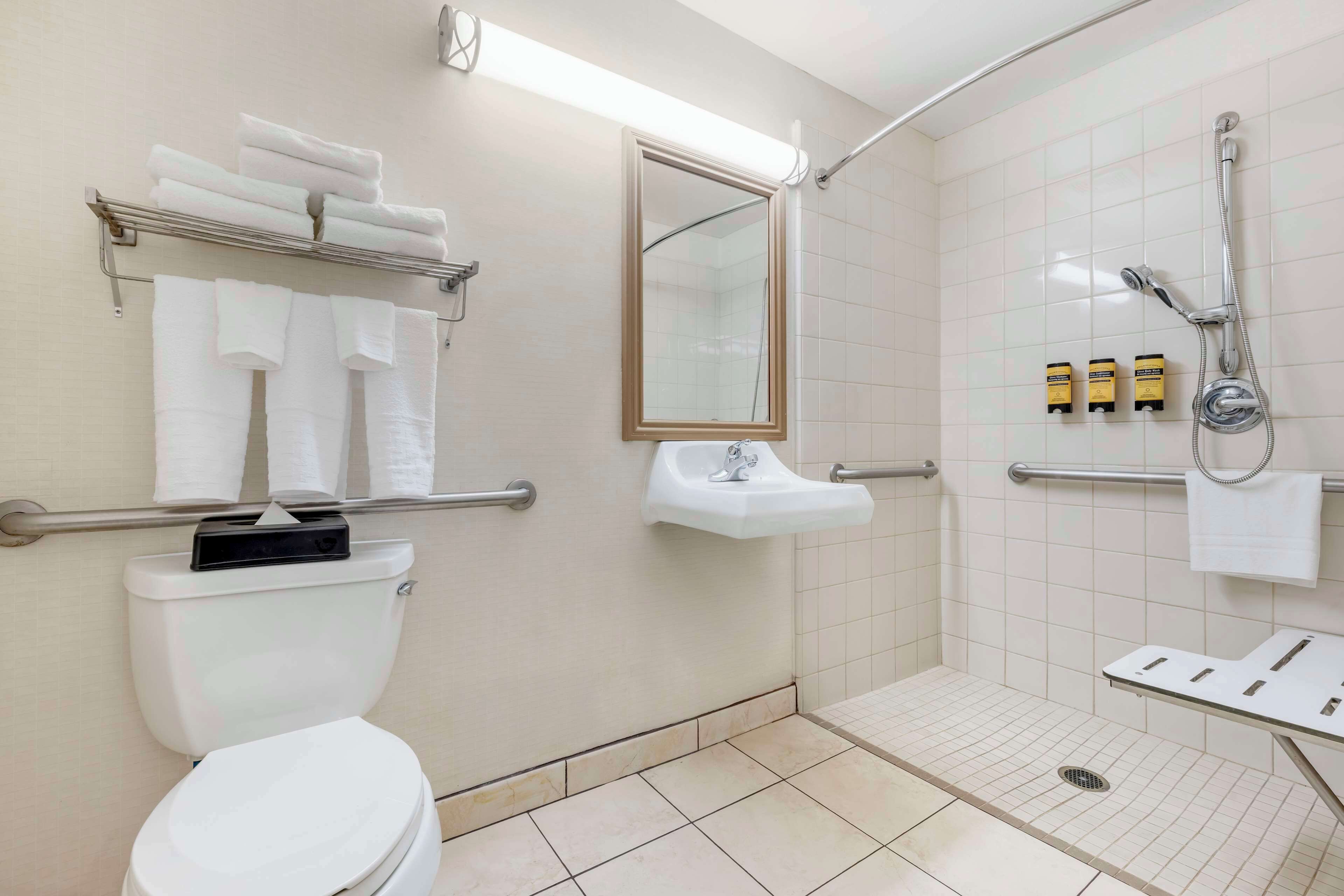 A bathroom with a toilet, sink, and shower area.