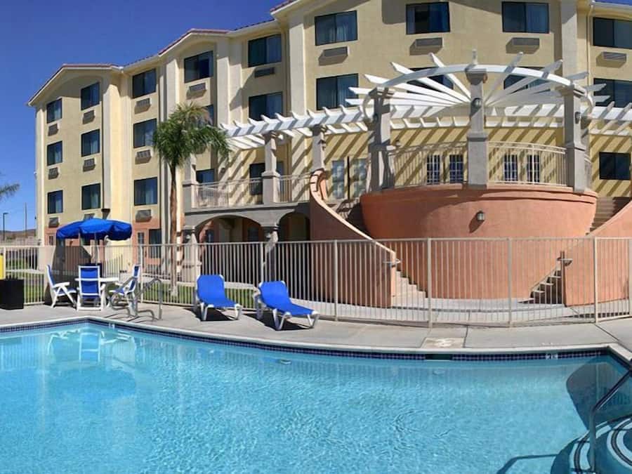 Een buitenzwembad, ligstoelen bij het zwembad