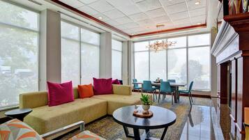 A modern interior with a sectional sofa, a round coffee table, and a dining area with chairs and a table.