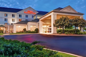 Um Hilton Garden Inn com entrada acessível, área de espera coberta e gramado bem cuidado.