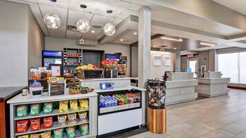 A snack kiosk with chips and salsa, a cash register, and a sign for 'The Shop'.