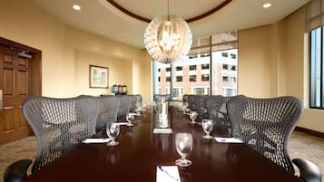 A conference room with a long table, multiple chairs, and a chandelier.