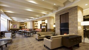 A spacious lobby with a fireplace, comfortable seating, and a television. - Hilton Garden Inn Baltimore Inner Harbor (Baltimore)