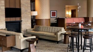 A modern living room with a fireplace, sofa, and bar stools.