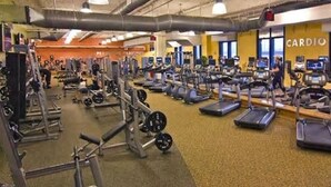 A gym with various exercise equipment, including treadmills and weight machines.