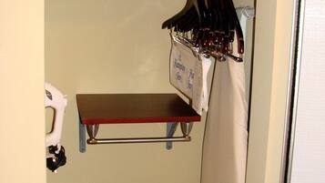 Un placard compact comprenant une tringle à vêtements, une étagère et un petit espace de rangement.