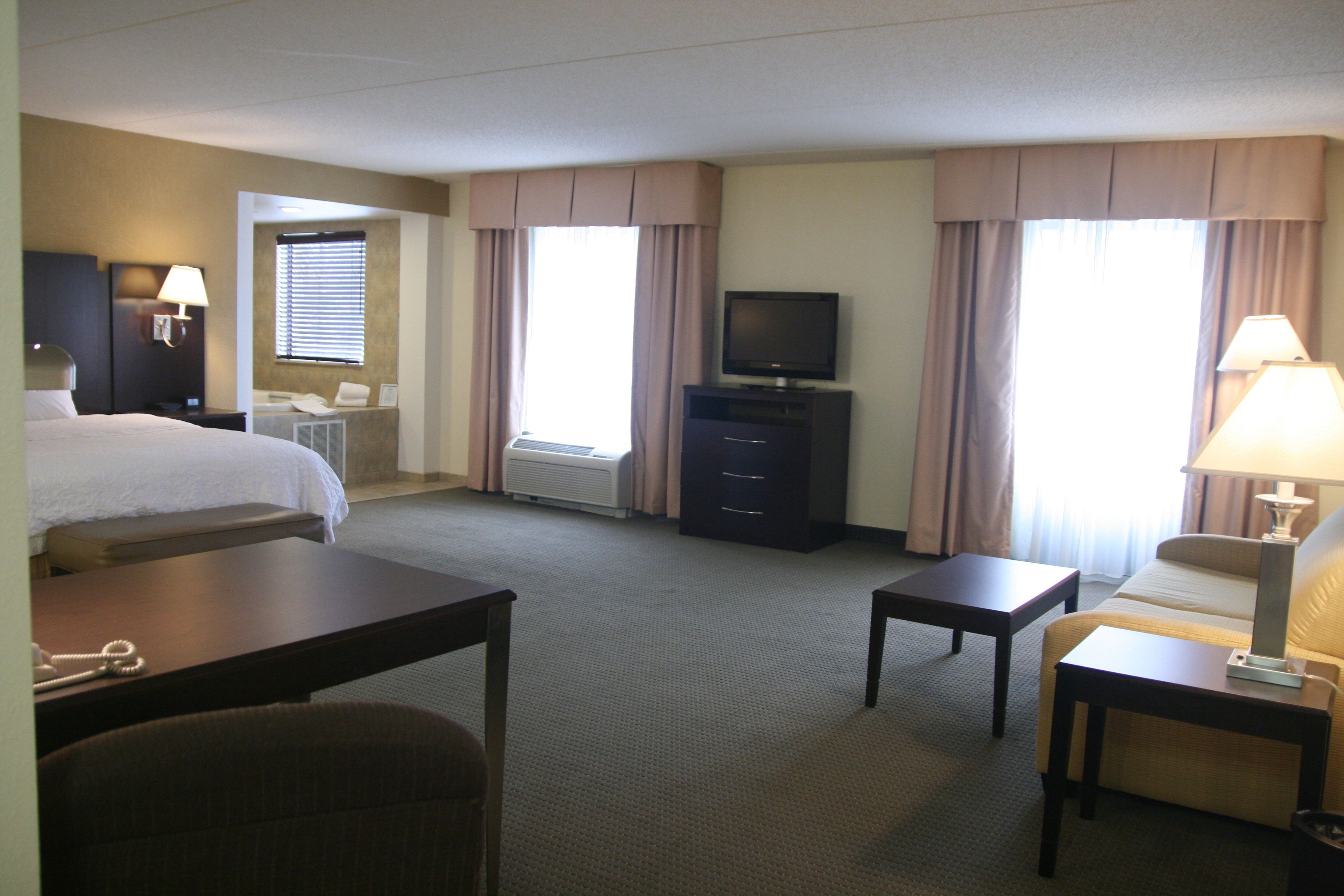 Une chambre d’hôtel équipée d’un lit, d’un bureau, d’une télévision, d’une chaise et d’une lampe.