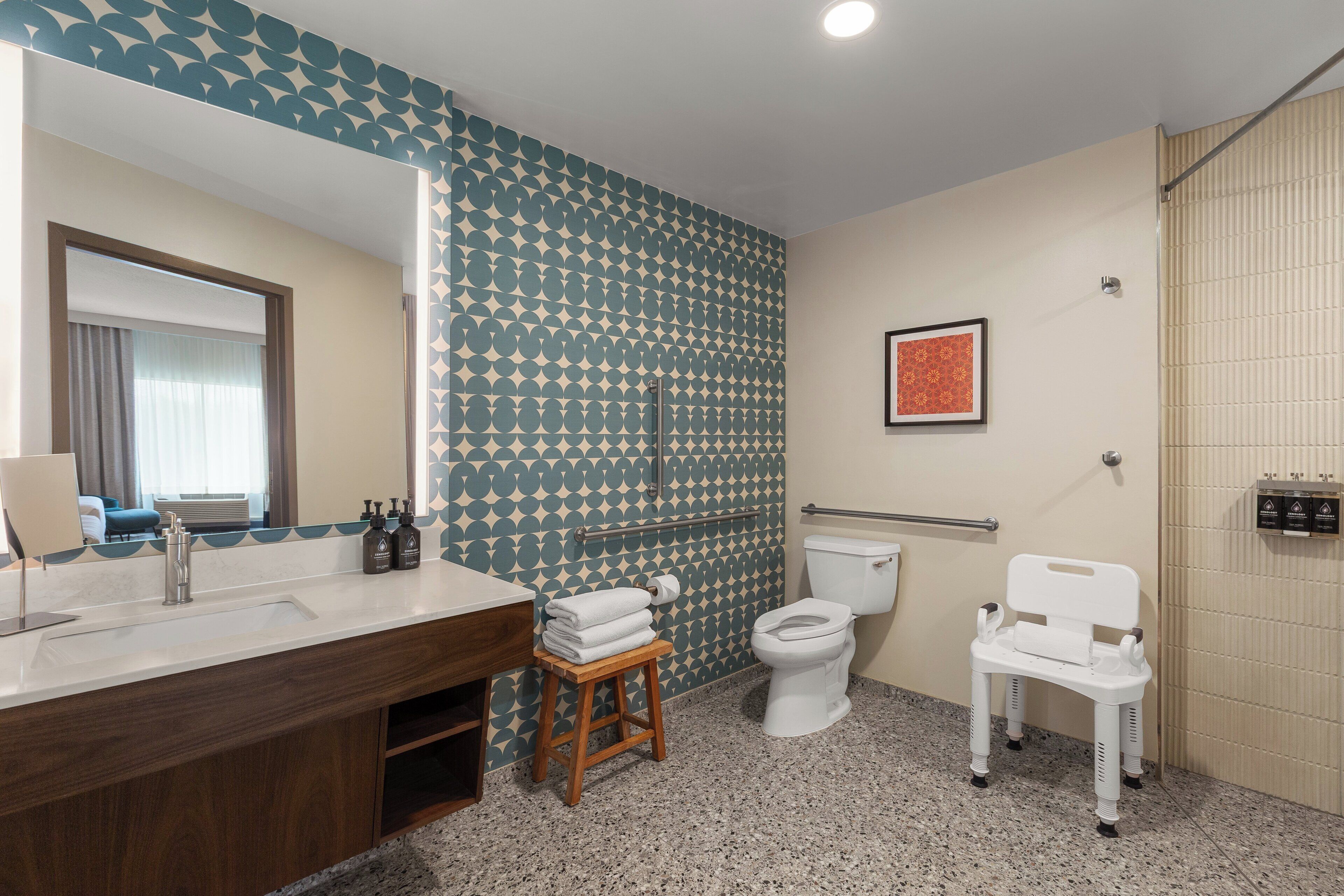 Un baño con lavamanos, inodoro y asiento de ducha.