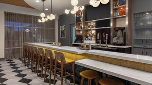 A modern bar area with a long counter, bar stools, and a variety of bottles and glasses. - Hotel Indigo Columbus Architectural Center by IHG (Columbus)