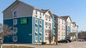 A multi-story hotel with a sign indicating extended stay options.