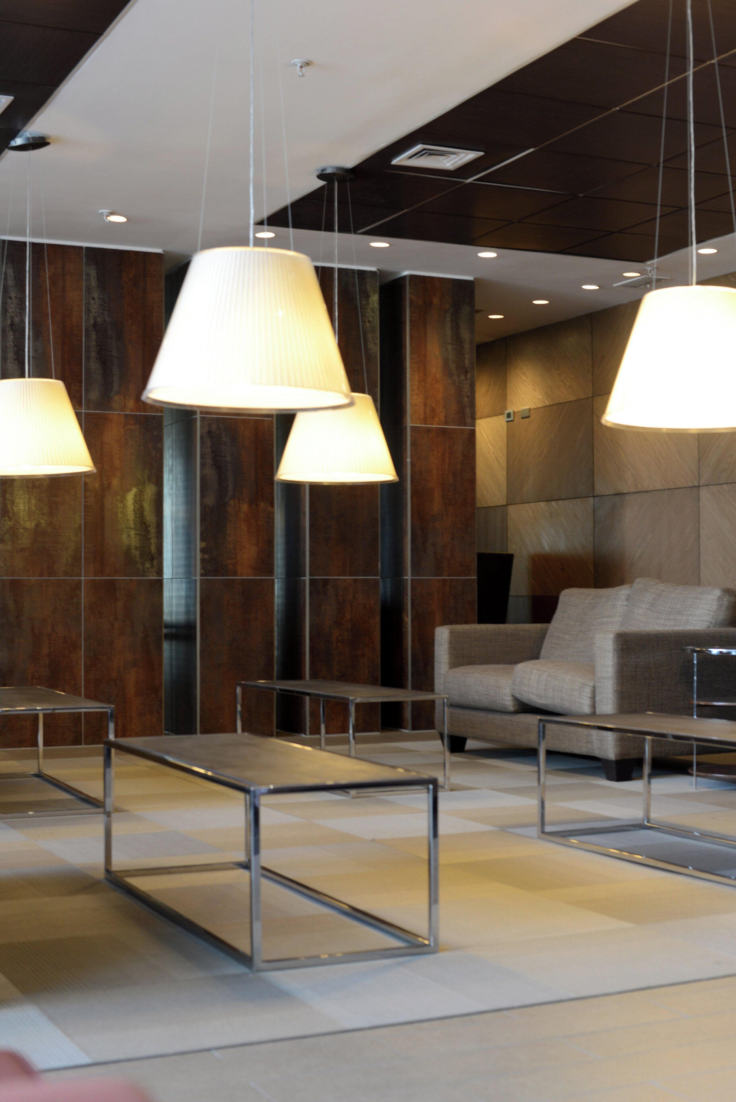 A modern interior with hanging lamps, a sofa, and a table.