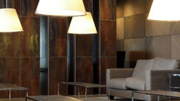 A modern interior with hanging lamps, a sofa, and a table.