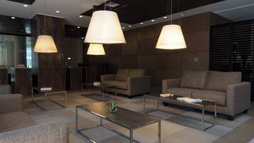 A modern lounge area with sofas, coffee tables, and pendant lighting.