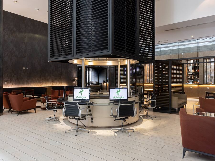 A lobby with a reception desk, seating area, and a bar.