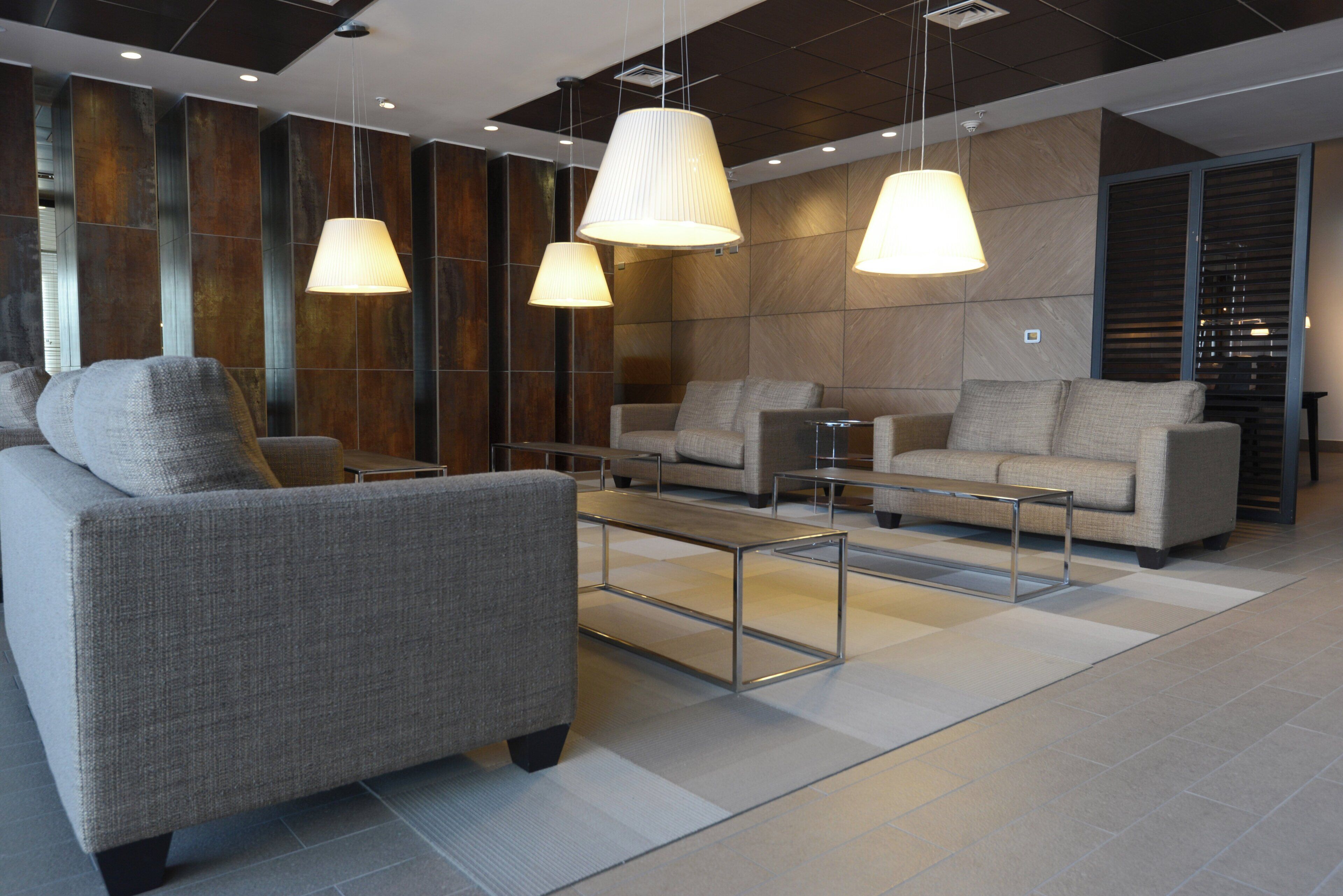 Un espace de détente moderne avec des canapés, une table basse et des luminaires suspendus.